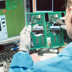 Engineer examining a PCB to represent electronics design and hardware development